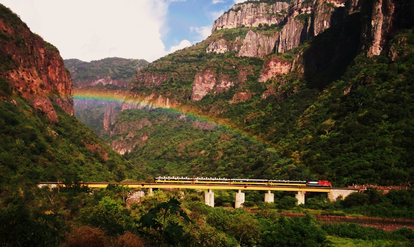 tren pasando por un puente en una montaña